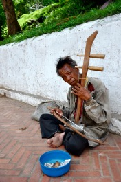 A man plays an instrument in Laos